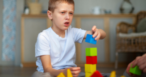 Child engaged in block-stacking activity during a neurodevelopmental therapy session at Ananta Care Clinic