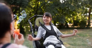 Child with cerebral palsy participating in outdoor rehabilitation therapy with supportive care