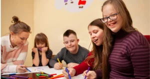 Children with Down syndrome enjoying guided art with a caregiver.