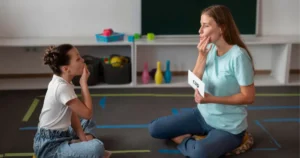 Child learning speech sounds with therapist using auditory verbal therapy