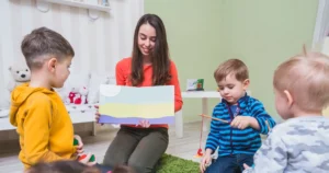 Early childhood therapist engaging with young children during a developmental learning session in a playroom environment.